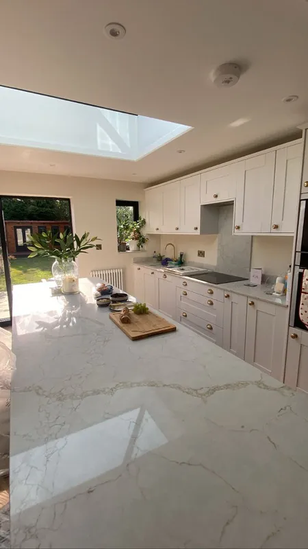 Kitchen in a single storey extension in Rugby, with a roof lantern, shaker units and a marble-effect island